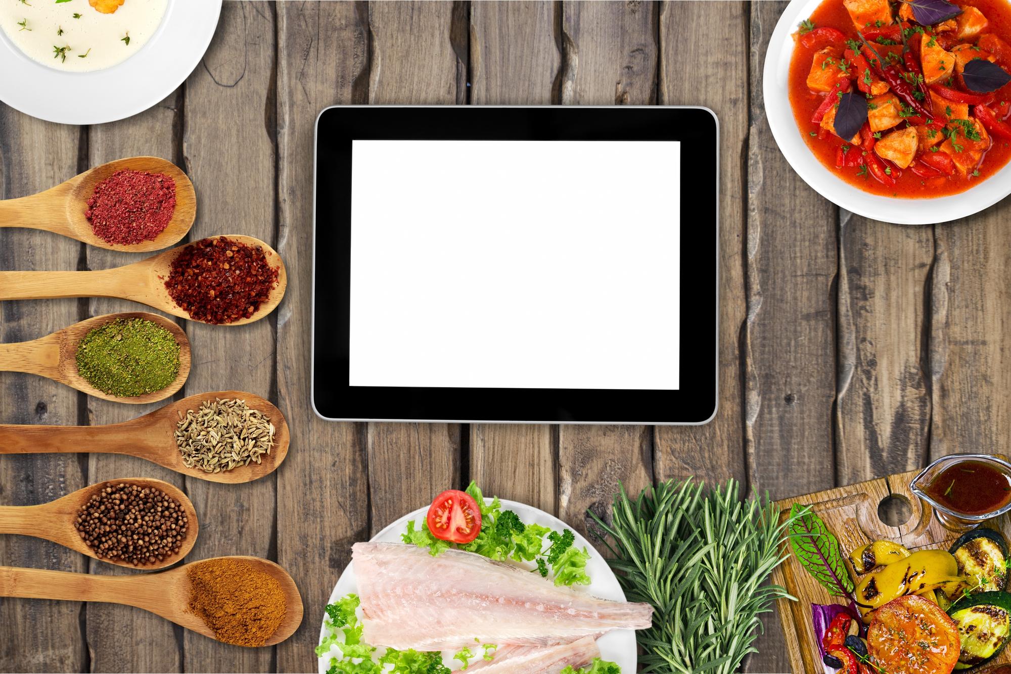 Mesa con platos preparados y tablet mostrando receta
